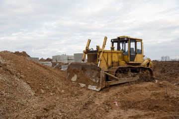 Bulldozer during land clearing and foundation digging at large construction site.  Crawler tractor with bucket for pool excavation and utility trenching. Dozer, Earth-moving equipment