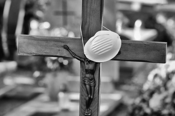 Cross on the grave of the deceased for coronavirus and a suspended anti epidemiological protective...
