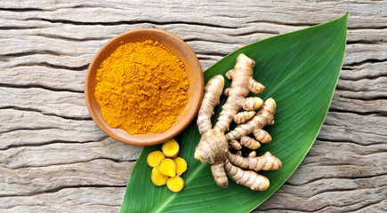 Fresh turmeric and powder turmeric on old wood background,Herbal