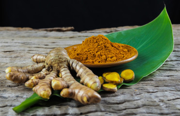 Fresh turmeric and powder turmeric on old wood background,Herbal