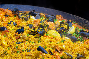 A large pan of seafood paella for sale on a market stall in the UK