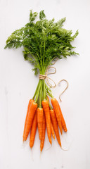 Bunch of fresh carrots over white background, top view

