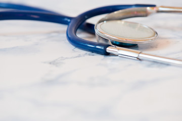 Macro shot of medical stethoscope or phonendoscope over light blue background.