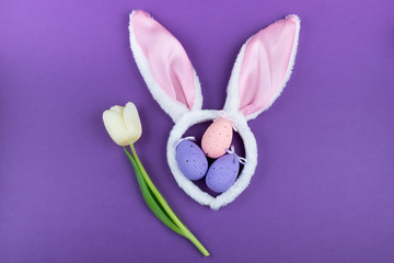 Easter holiday. Festive composition with carnival rabbit ears on a purple background. Postcard for the Easter holiday