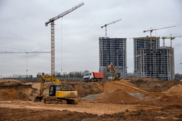 Excavator load the sand to the heavy dump truck on construction site. Backhoe at earthworks. Digs a...