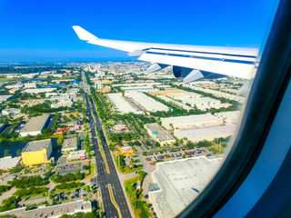 Fototapeta na wymiar Miami from airplane porthole at day with blue sky