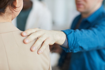 Close up of male hand on shoulder, people comforting each other in psychology support group, copy space