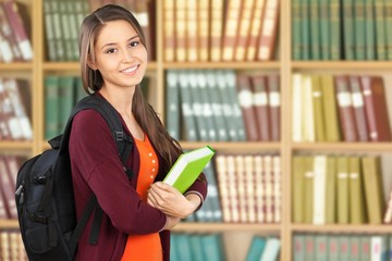 Young female college student on library background