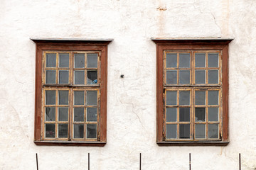Fototapeta na wymiar Wall of a residential building with closed windows and old stucco House Exterior Details in Estonia