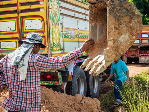Workers are carrying out soil work with excavator and truck