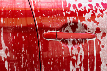 Manual car wash. Cleaning Car Using High Pressure Water. Washing with soap. Close up concept.