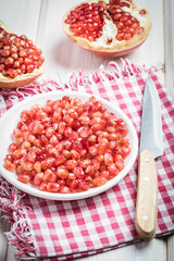 pomegranate and seeds on a plate and silver spoon