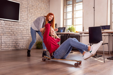 Business people having fun with skateboard at the office