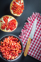 pomegranate and seeds on a plate and silver spoon