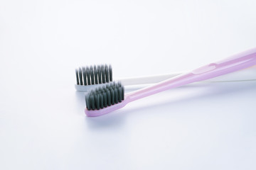 Two beautiful multi-colored toothbrushes with black shields, on a white background. Close-up. Is isolated.