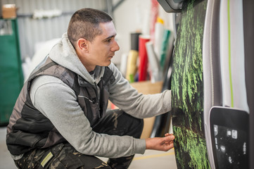 Technician operator works on large premium industrial printer plotter machine