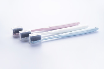 Multi-colored toothbrushes with black bristles on a white background.
