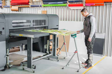 Technician operator works on large premium industrial printer plotter machine