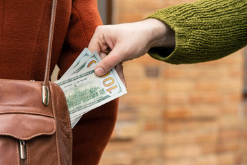 steal money from handbag woman fashion cloth and male hand with dollars cash concept street