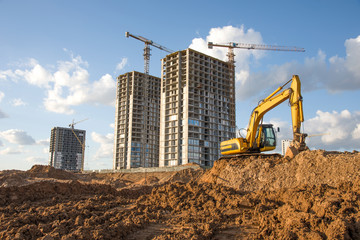Excavator during Earthmoving Works at construction site. Backhoe digs the foundations of the...