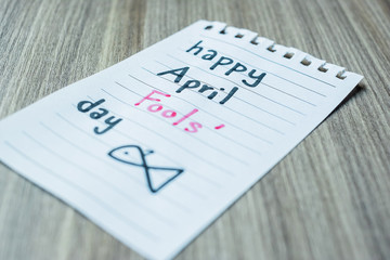 white paper note with the text April Fools day on wood table