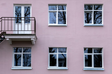 Fototapeta na wymiar Wall of a residential building with closed windows and old stucco House Exterior Details in Estonia