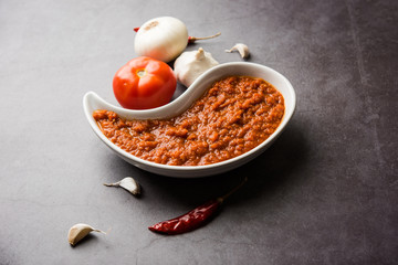 onion tomato masala or puree for indian gravy, served in a bowl with raw tamatar, pays and lehsun...