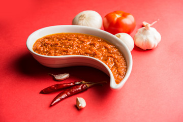 onion tomato masala or puree for indian gravy, served in a bowl with raw tamatar, pays and lehsun and red chilli, selective focus
