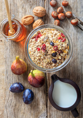 Breakfast concept. A jar with oatmeal, fruits and nuts on wood