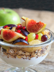 Breakfast with Yogurt, muesli and fresh fruits in a bowl, blur background