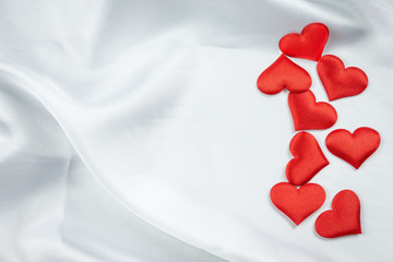 Many red hearts on a wrinkled white background