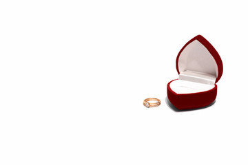 Gold ring and red jewelry box on white background