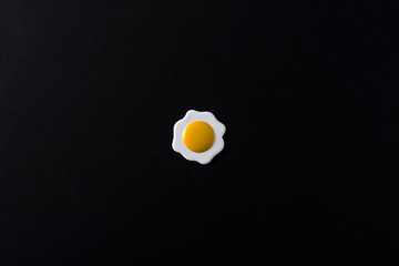 Minimalist fried egg black background. Top view