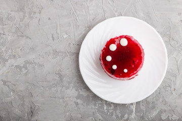 Red cake with souffle cream on a gray concrete  background. top view.