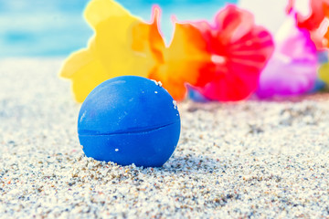 Close up of a ball and other beach objects on the sand