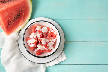 Watermelon fruit cutted with yogurt in bowl on turquoise background