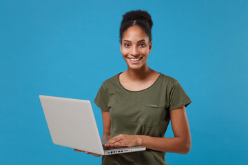 Cheerful young african american woman girl in casual t-shirt posing isolated on blue background...