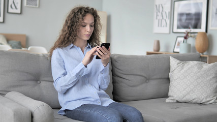 Obraz premium Excited Curly Hair Woman Successfully Shopping Online on Smartphone
