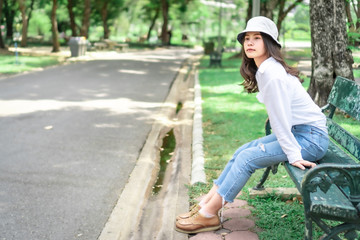 Obraz premium Beautiful Asian women with long hair wearing a white shirt. White bug hat, jeans showing emotions In the nature park-09.jpg, Asian beautiful woman with yellow skin, long black hair, wearing a white s