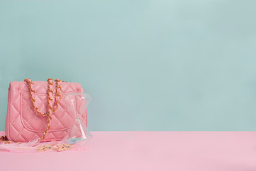Fashion concept with bright colored accessories. Pink handbag and feathers