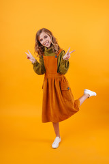 Smiling little girl wearing a dress standing isolated