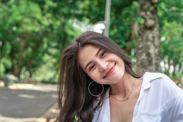 Naklejka premium Beautiful Asian women with long hair wearing a white shirt. White bug hat, jeans showing emotions In the nature park-09.jpg, Asian beautiful woman with yellow skin, long black hair, wearing a white s