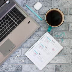 Concept layout of work place. Notebook, planner and a cup of coffee on a stone background