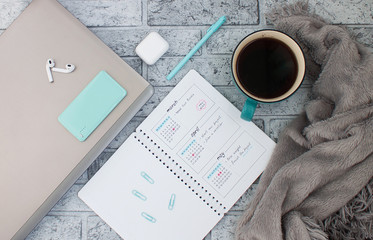 Concept layout of work place. Notebook, planner and a cup of coffee on a stone background