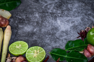 Thai food ingredients that are spicy, such as kaffir lime leaves, garlic, onions, lemons, galangal, red peppers, various herbs, food concept on the ground, copy space