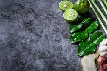 Thai food ingredients that are spicy, such as kaffir lime leaves, garlic, onions, lemons, galangal, red peppers, various herbs, food concept on the ground, copy space