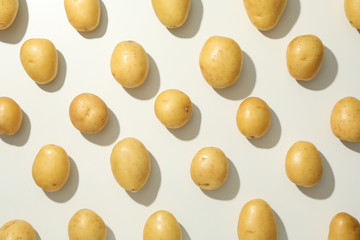 Flat lay with young potato on white background, top view