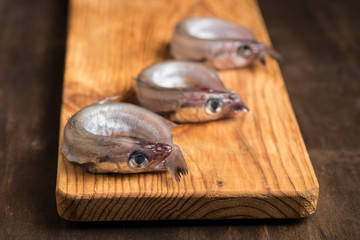 Blue whiting or lilies, fish on the table prepared to be cleaned and cooked in different ways, battered, baked, pickled. Tasty and healthy seasonal white fish.