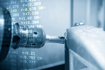 The abstract scene of 5 axis CNC milling machine cutting the automotive parts with solid ball endmill tools. The hi-technology automotive part manufacturing process by 5 axis machining center. © Pixel_B