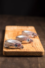 Blue whiting or lilies, fish on the table prepared to be cleaned and cooked in different ways, battered, baked, pickled. Tasty and healthy seasonal white fish.